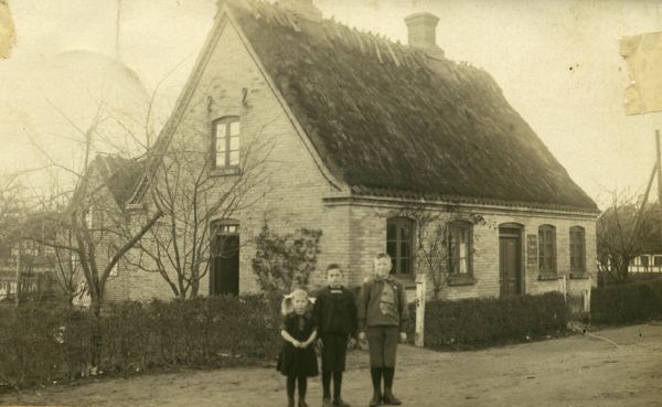 1918 Emmas barndomshjem i Bovense
Foran huset står Valborg (Emmas søster Marthas datter), Richard og Thorvald (Emmas brødre).
Nøgleord: Bovense;valborg_sørensen;richard_andersen;thorvald_andersen